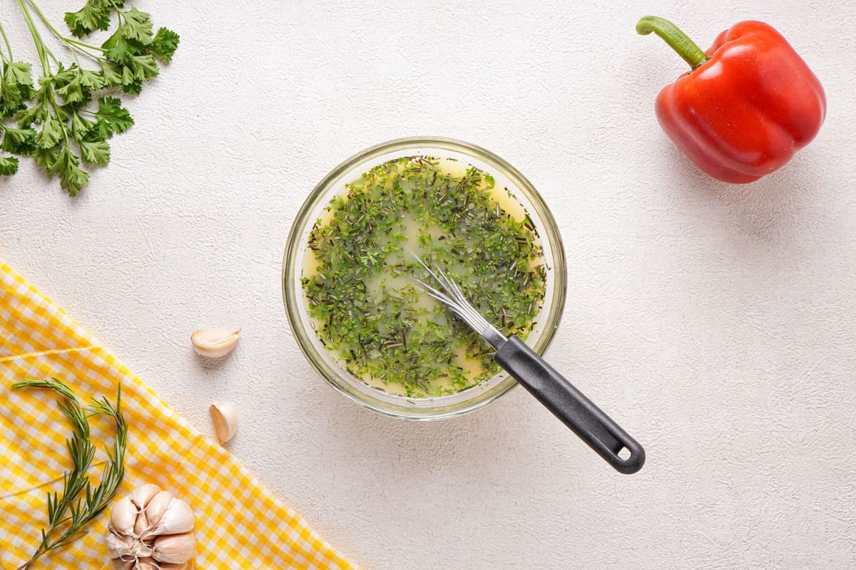 mixing broth and herbs in small glass bowl