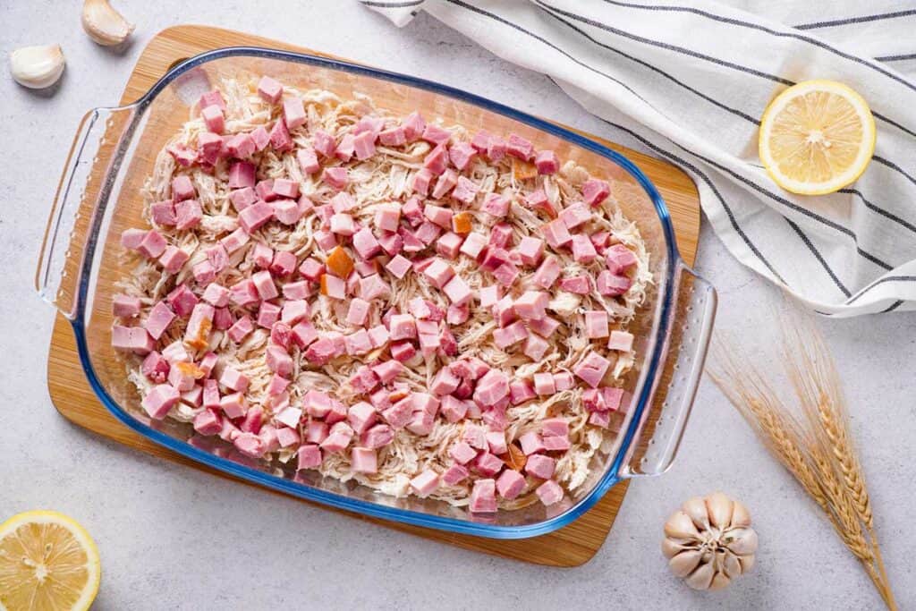 rotisserie chicken and ham cubes in glass casserole dish