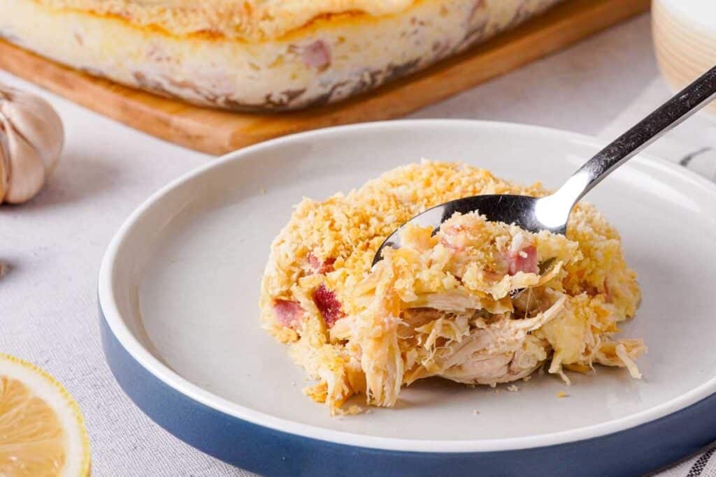 spoon getting bite out of piece of chicken cordon bleu casserole