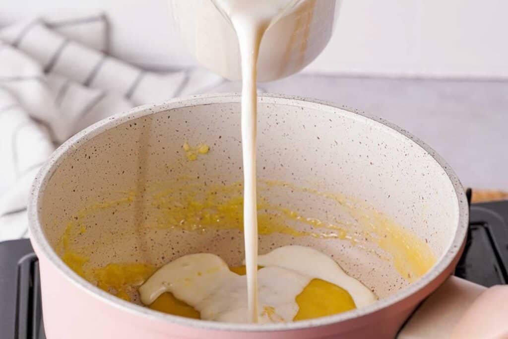pouring milk into a saucepan