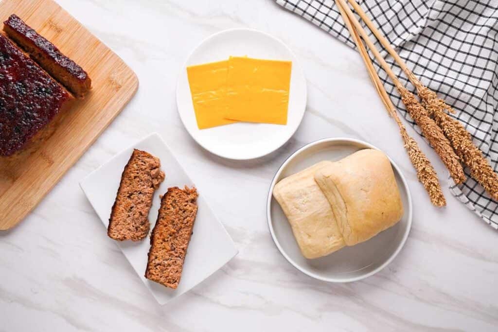 meatloaf, slices of cheese, and ciabatta bread for meatloaf sandwiches