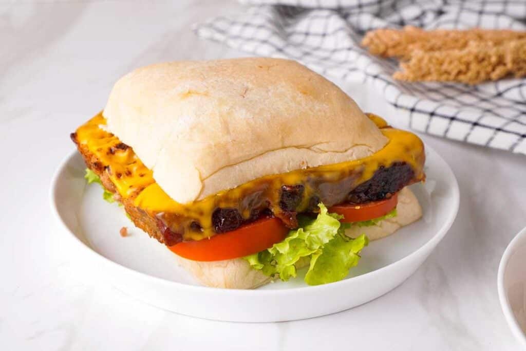 meatloaf sandwich on ciabatta bread with lettuce and tomato and cheese