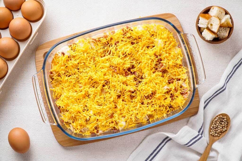 breakfast casserole topped with shredded cheese before baking