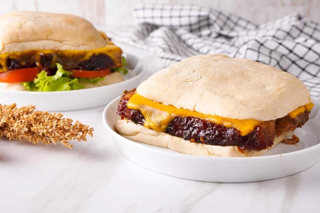 two meatloaf sandwiches on white plates