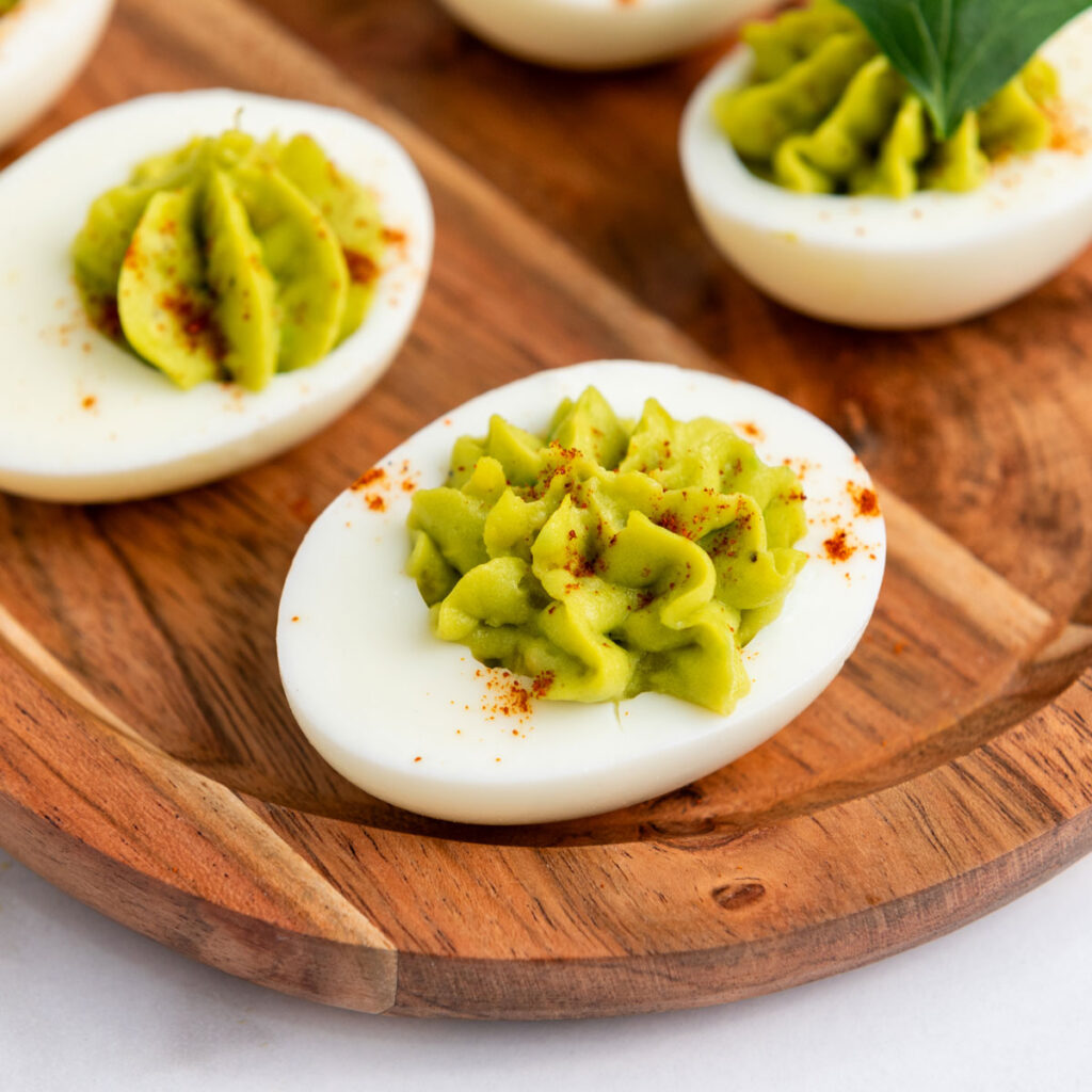 avocado deviled eggs on wood tray