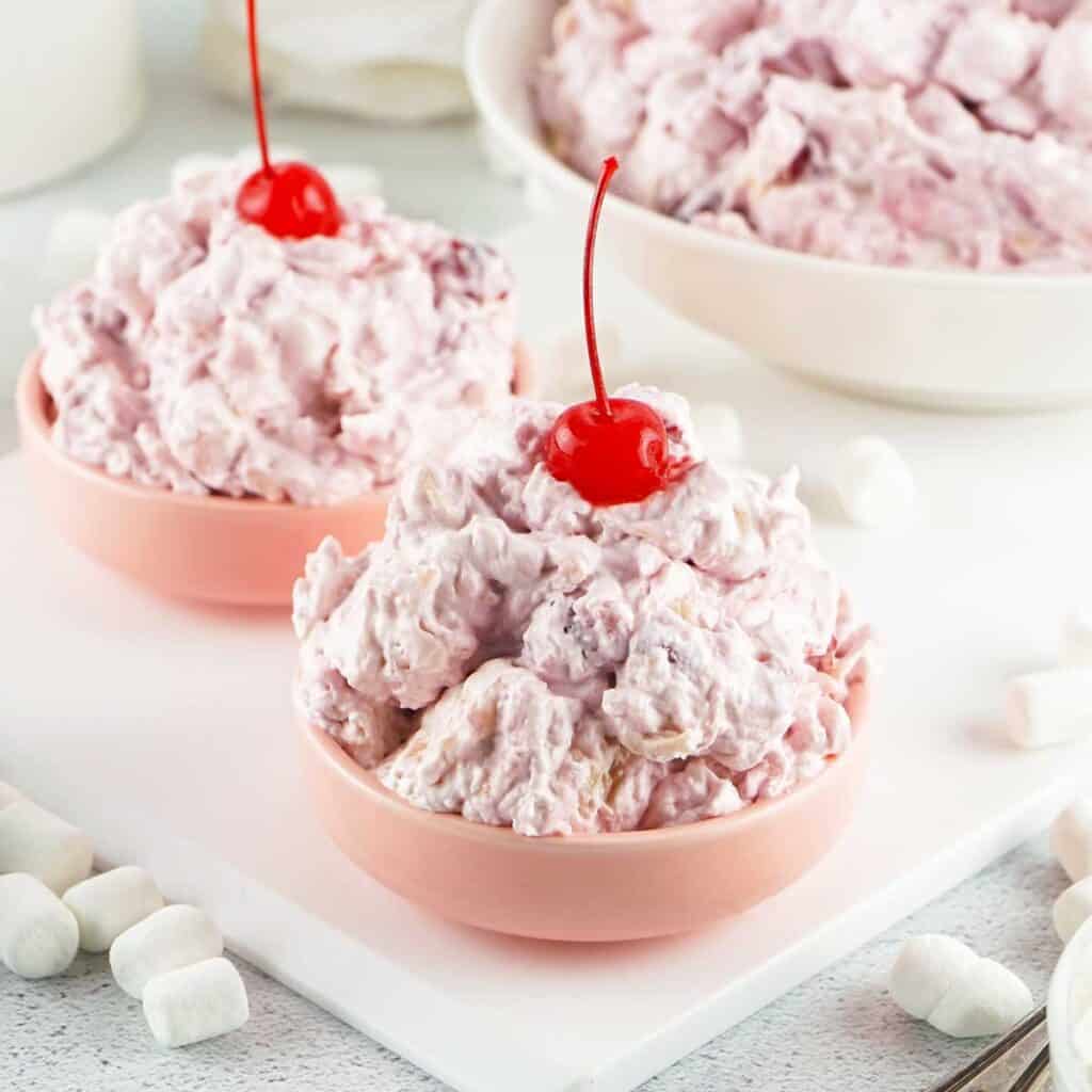 two bowls of cherry fluff topped with cherries