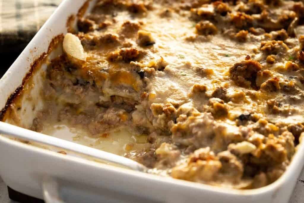 hamburger potato casserole in baking dish with a serving removed