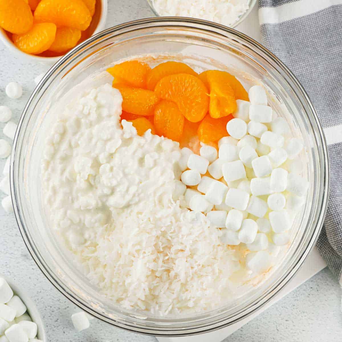 orange fluff jello salad ingredients in glass bowl