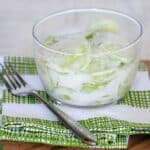 cucumber salad with creamy dressing in glass bowl