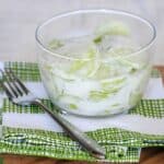cucumber salad with creamy dressing in glass bowl