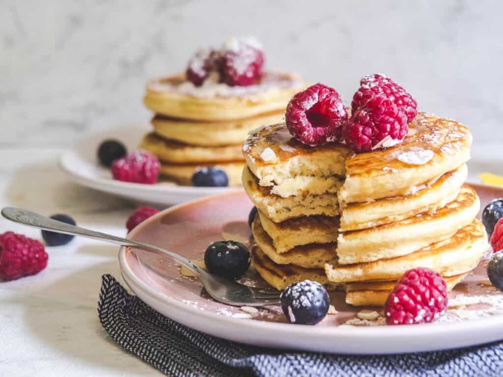 stack of light and fluffy pancakes with bite removed