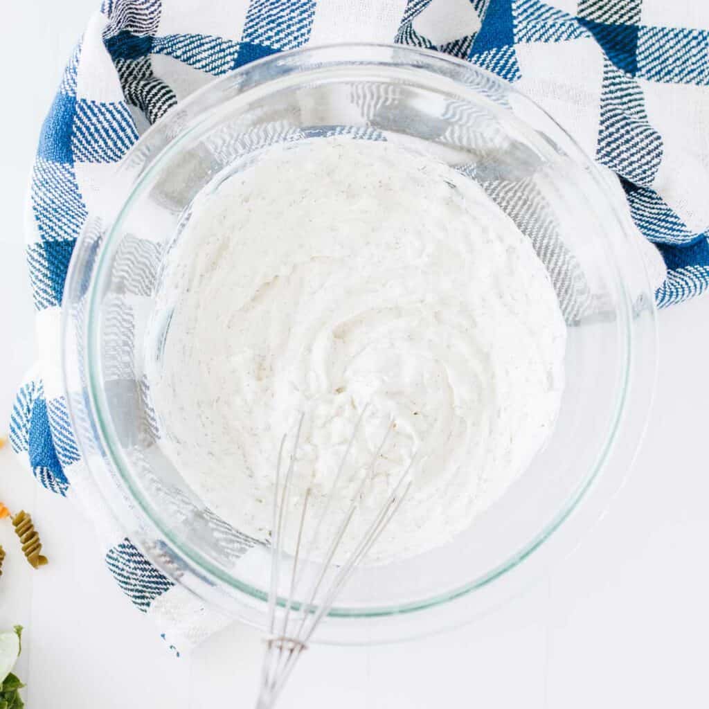 glass bowl with BLT pasta salad dressing and whisk