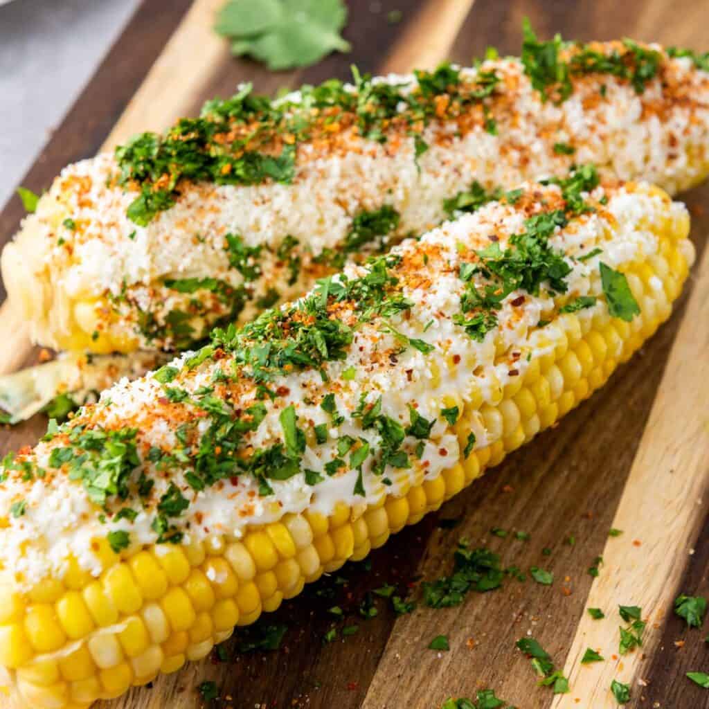 two elotes on cutting board