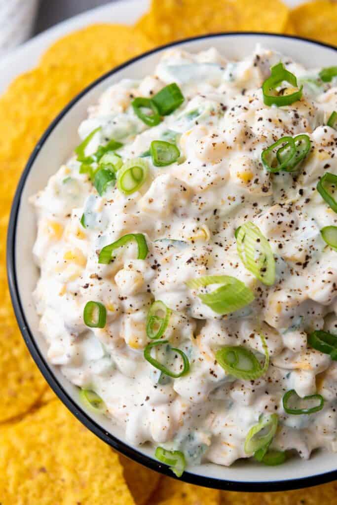 extreme close up on crack corn dip with chopped green onion on top