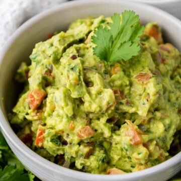 close up of guacamole in white bowl