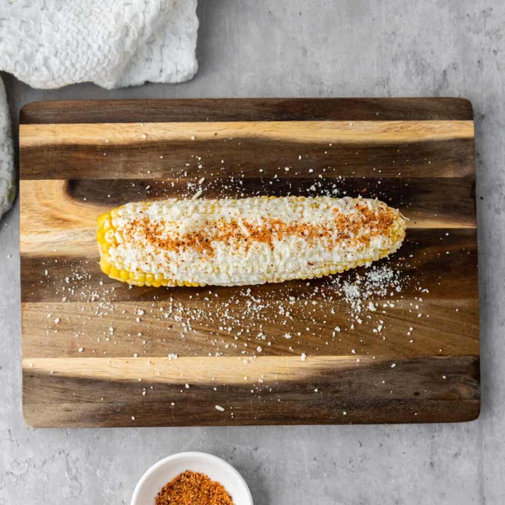 corn cob with mayonnaise, cotija cheese, and chili powder