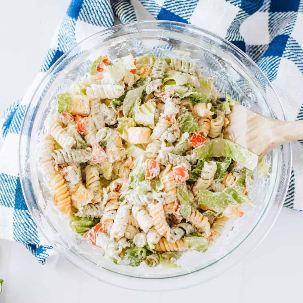 glass bowl with BLT pasta salad and wooden spoon
