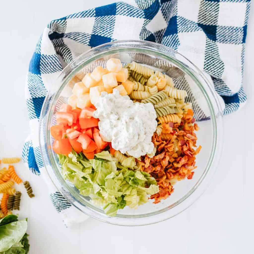 glass bowl with BLT pasta salad ingredients before mixing