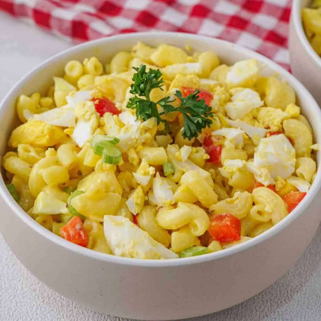 white bowl with Amish macaroni salad garnished with parsley