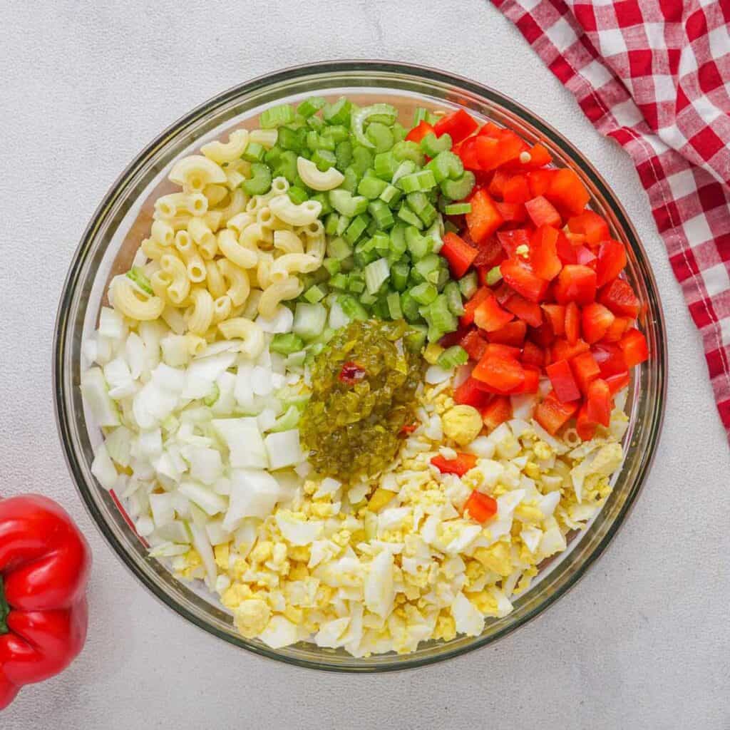 Amish macaroni salad ingredients in glass bowl