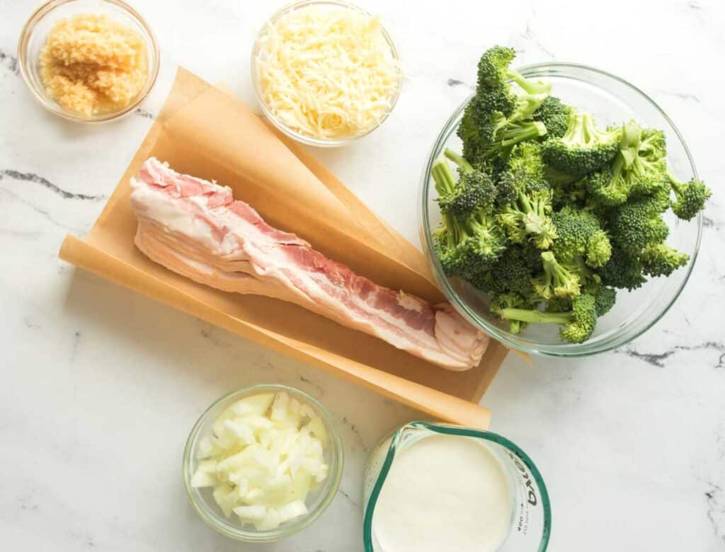 creamy bacon and broccoli ingredients on marble countertop