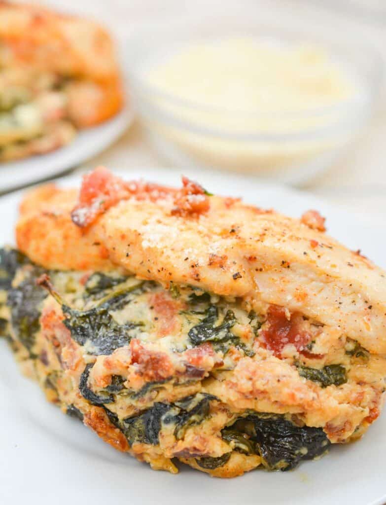 close up of spinach stuffed chicken breast with bacon crumbles