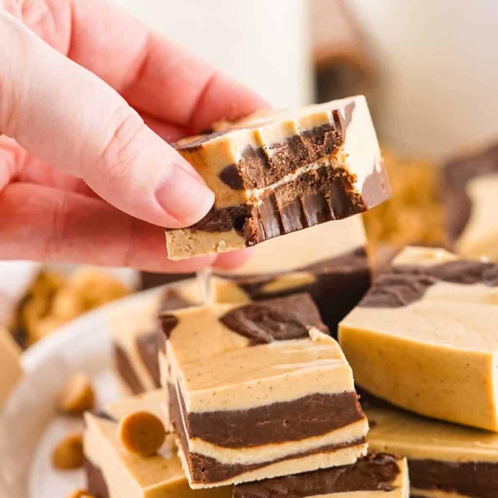 hand holding piece of chocolate peanut butter fudge with bite taken out of it