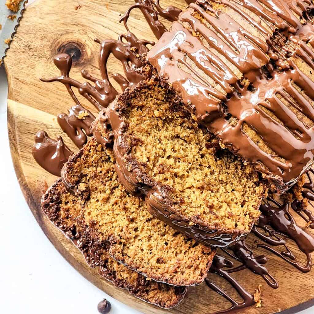 overhead view of pumpkin spice bread topped with chocolate and sliced twice