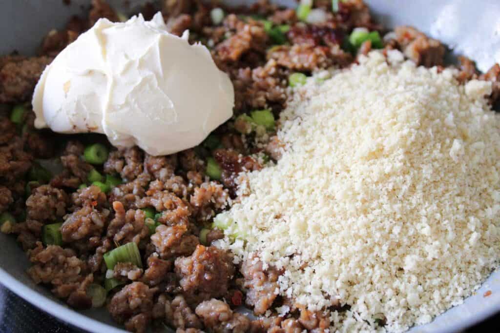 adding breadcrumbs and mascarpone to ground sausage