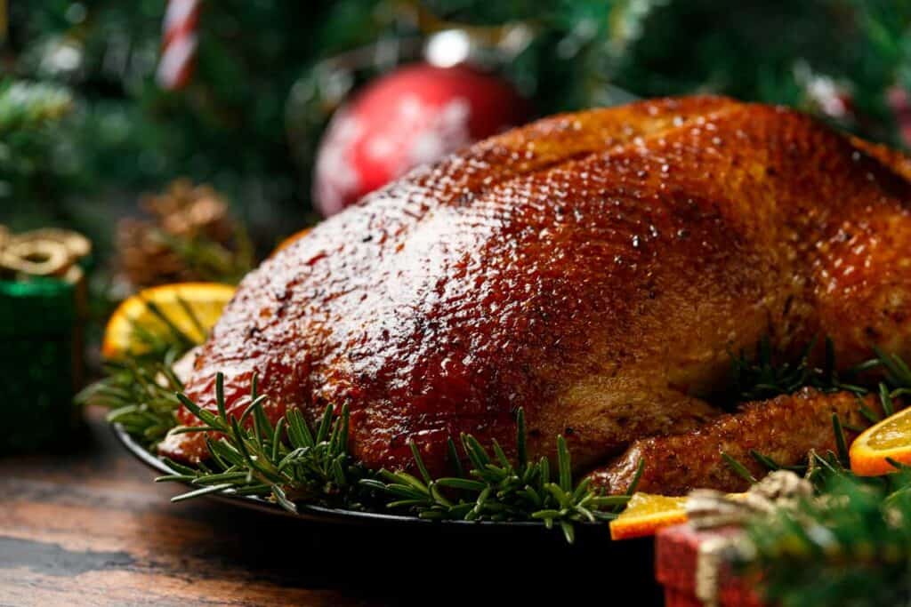 roast duck on platter with rosemary