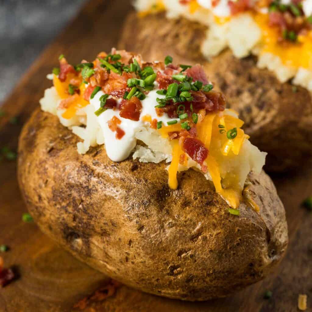 baked potato with sour cream, cheese, and bacon bits