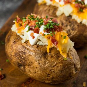 baked potato with sour cream, cheese, and bacon bits