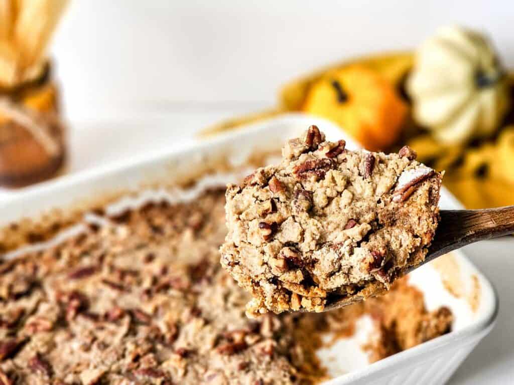 wooden spoon holding scoop of sweet potato dump cake