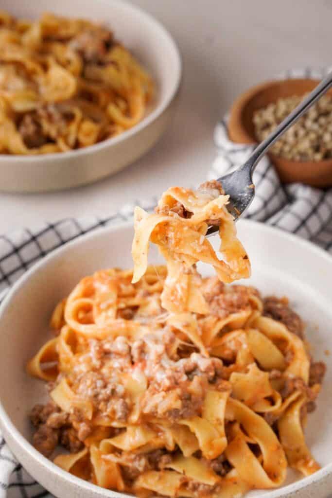 fork with bite of crock pot ground beef and noodles