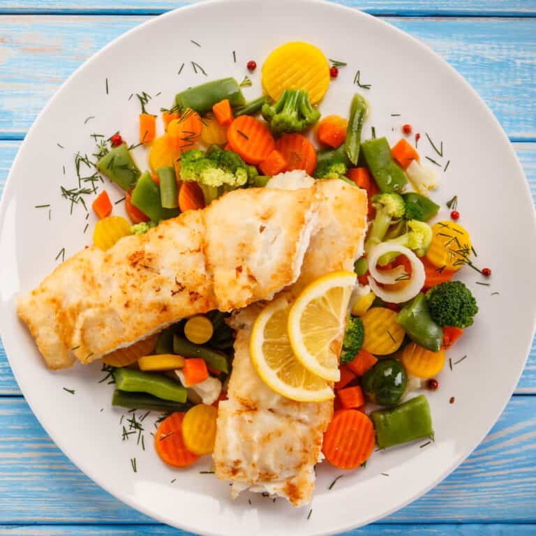 overhead view of flounder and vegetables on white plate