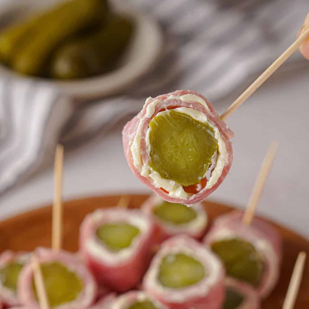 close up of ham and pickle roll up on toothpick