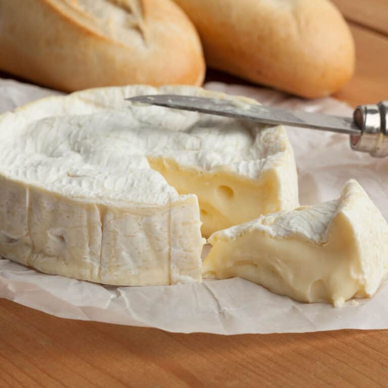 wheel of camembert cheese with wedge cut out