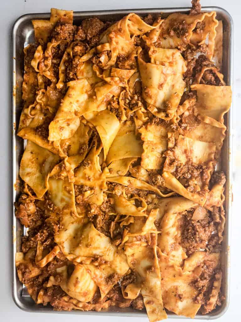 lasagna noodles in meat sauce on baking sheet