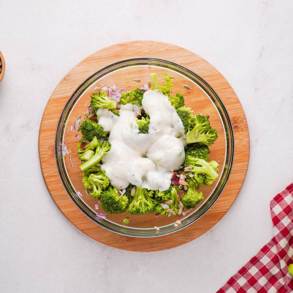 broccoli with dressing poured on in glass bowl