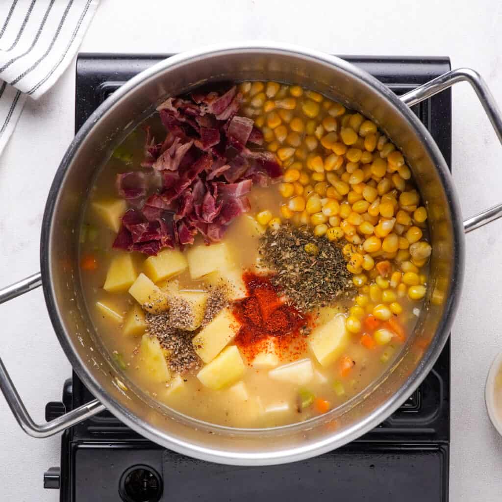 corn, bacon, and potatoes in broth in pot