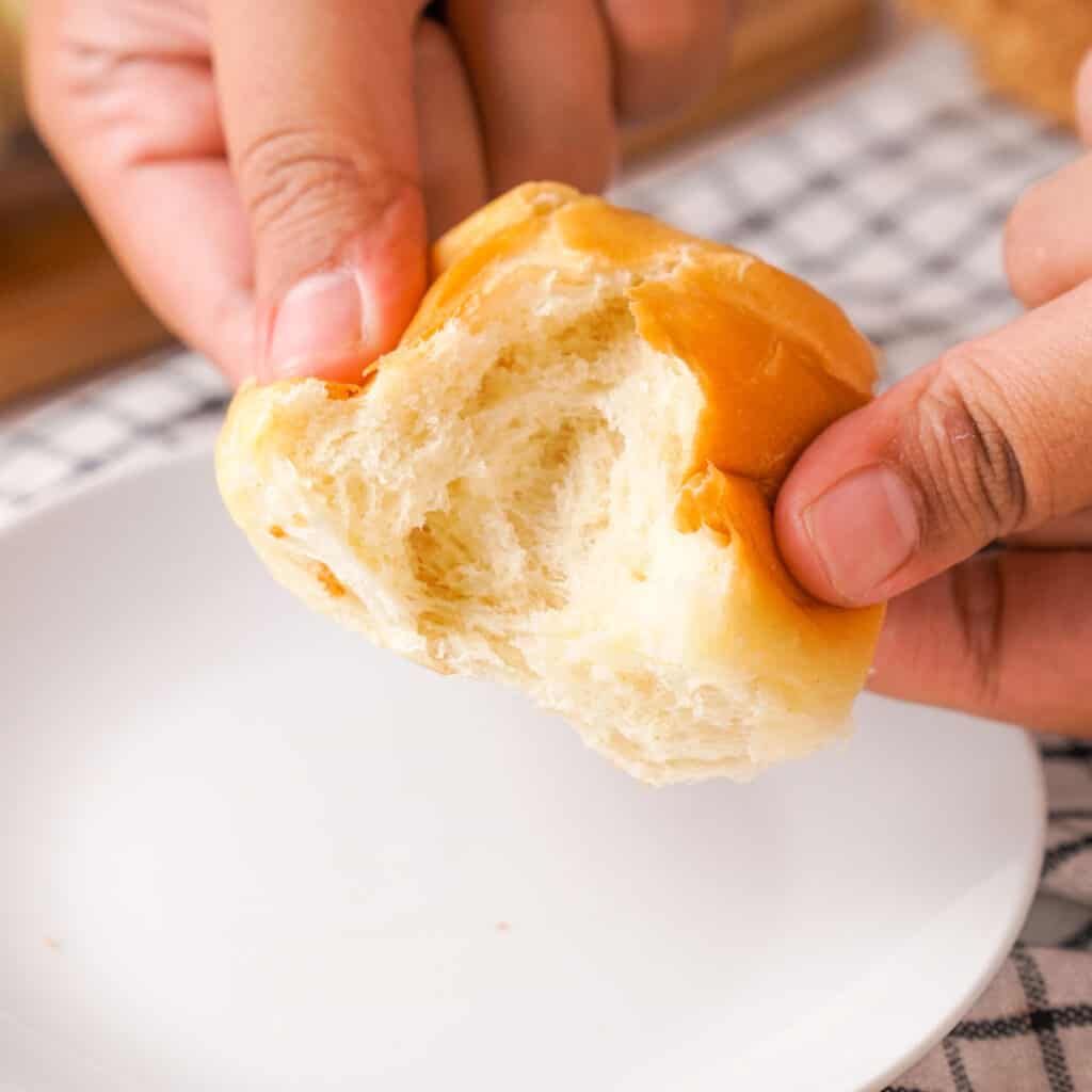 hand breaking open dinner roll