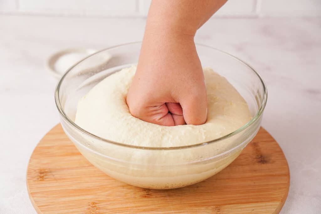 hand punching ball of dough