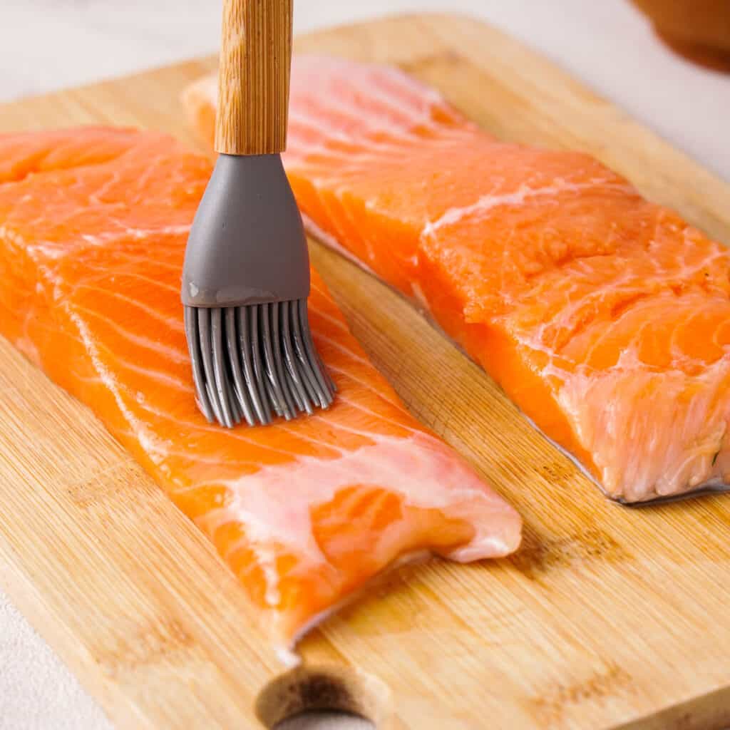 brushing raw salmon with oil