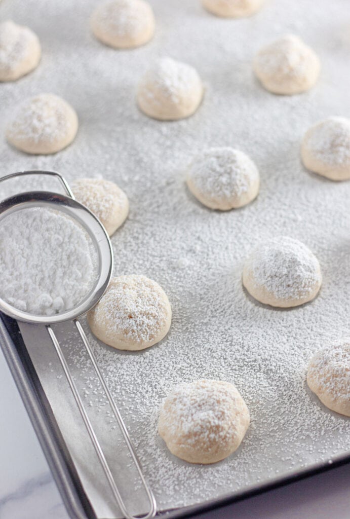 dusting cream cheese cookies with powdered sugar