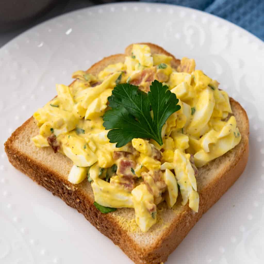 egg salad with bacon on a pice of bread