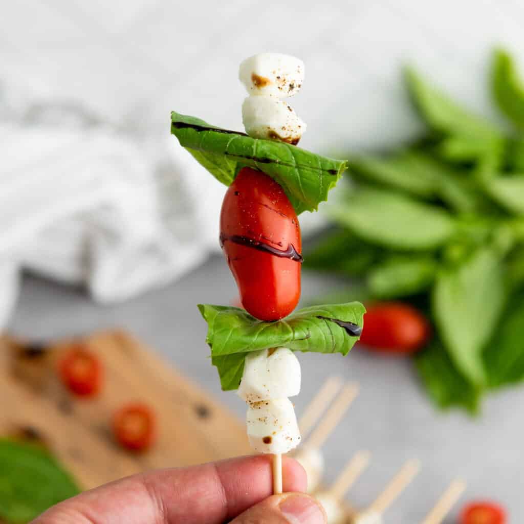 hand holding caprese skewer