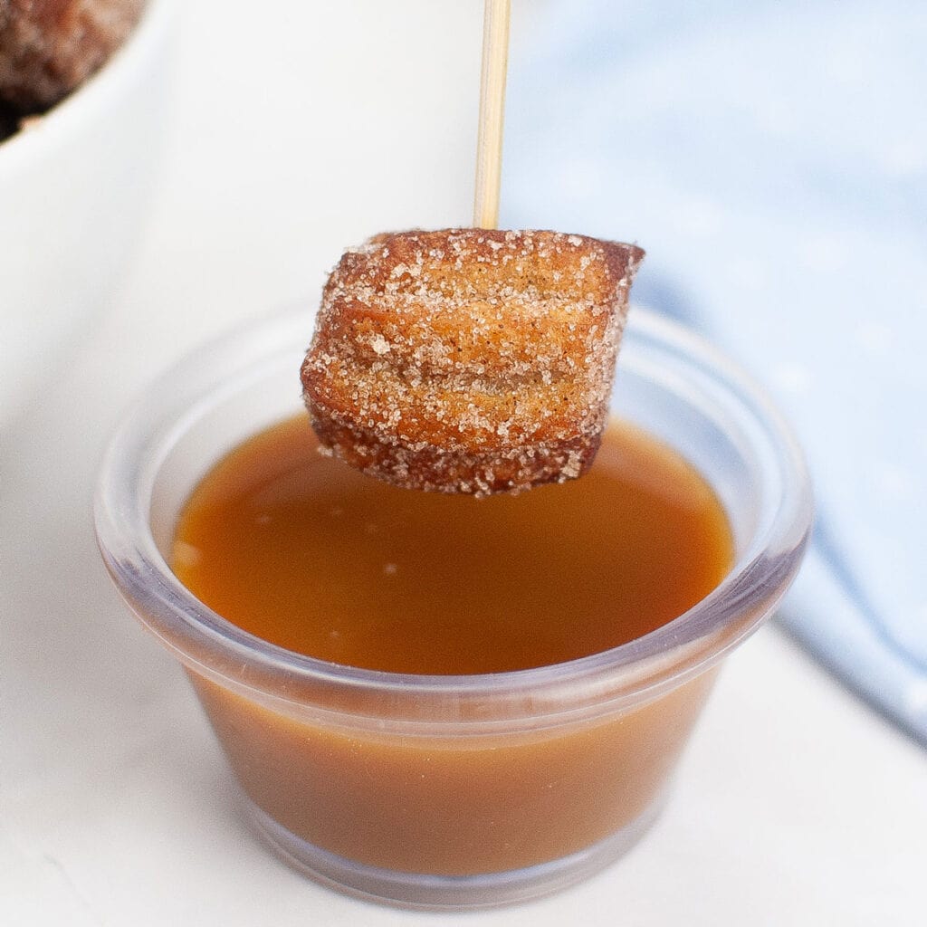 churro bite on skewer with caramel sauce