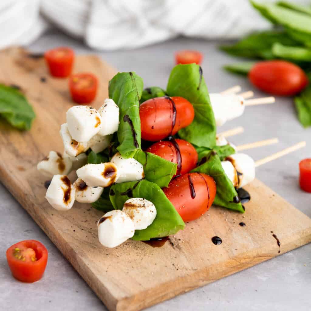 stack of caprese skewers on cutting board