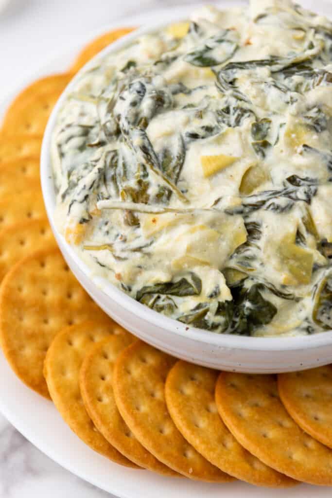 Slow Cooker Spinach Artichoke Dip with round crackers