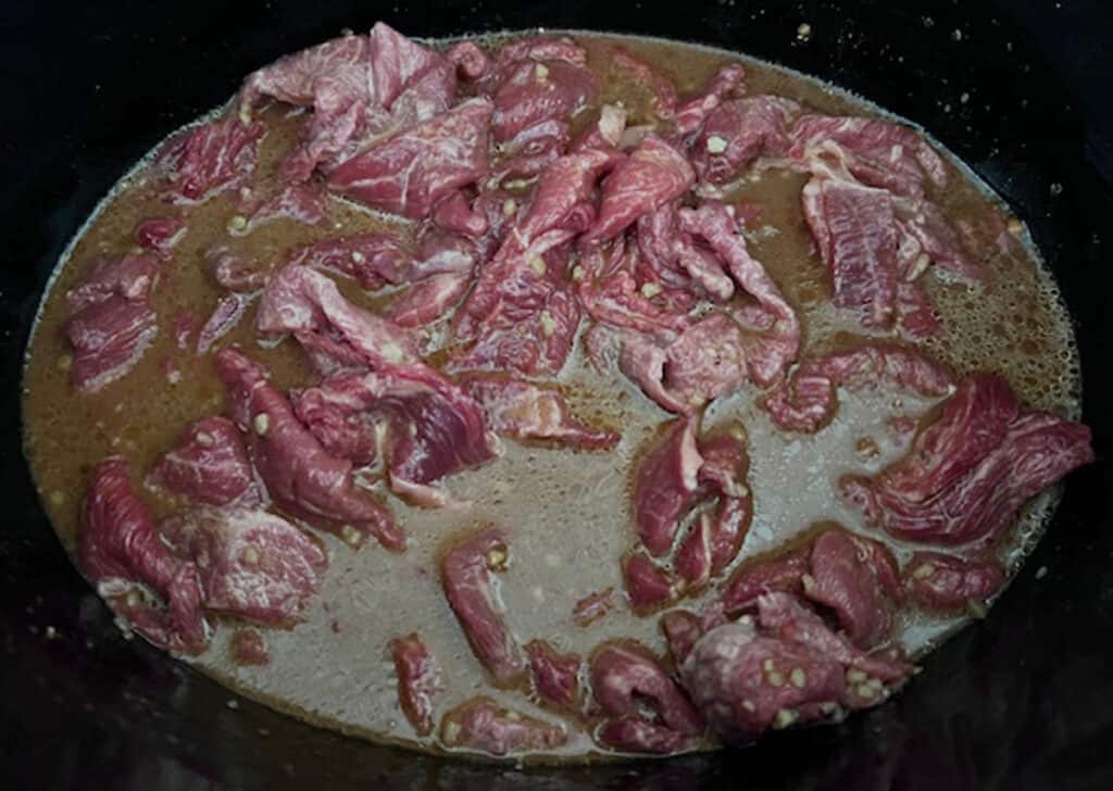Mongolian beef and sauce before cooking in slow cooker